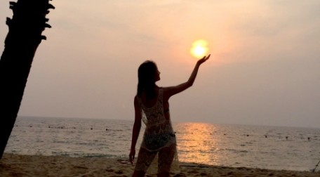 幸運の女神は前髪しかない！婚活で良いパートナーに巡り合う為には決断が大切です。それを表現した美しい女性が沈む夕日をまるで手で掲げているように見える神々しい写真で表現しています。