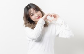 情けは人の為ならず、人に対して情を与えることは回りまわって自分にかえってくる、このことを表すために情勢が自分の両手で💗マークを作り「情」の大切さを訴えている写真。