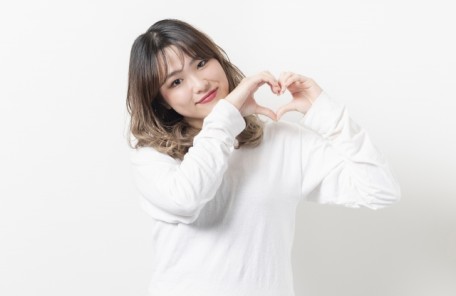 情けは人の為ならず、人に対して情を与えることは回りまわって自分にかえってくる、このことを表すために情勢が自分の両手で💗マークを作り「情」の大切さを訴えている写真。