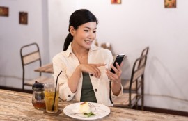 40代の婚活は結婚相談所で！のテーマに合わせ40歳代の女性が食事をしながらスマホでお相手検索をしている写真。気楽にお相手探しができます。