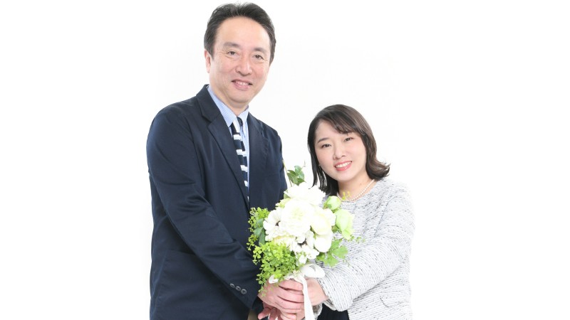 大阪結婚相談所ビリーブインユアセルフの夫婦カウンセラーが二人で結婚したい思いを持つ方々へ幸せのバトンタッチとしてブーケを掲げる写真。「次はあなたに成婚をお贈りします」イメージ写真。