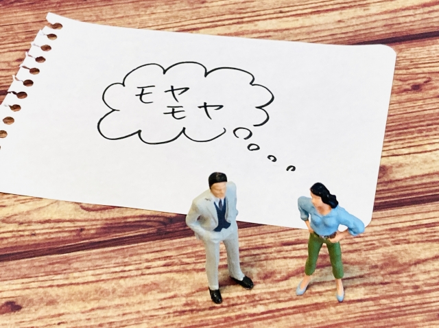 婚活における「お相手への違和感」というテーマの写真。dん製と女性の人形が「モヤモヤ」という吹き出しで表現している図。