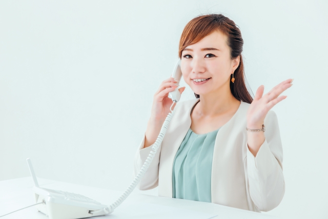 女性が問い合わせの電話をしているイメージ写真。