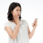 「婚活は難しい」とスマホを見ながら悩んでいる女性の写真。大阪結婚相談所ビリーブインユアセルフではこういう方の悩みを解消します。