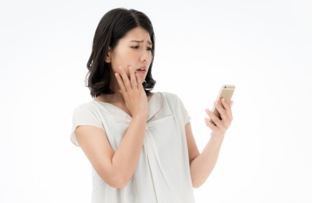 「婚活は難しい」とスマホを見ながら悩んでいる女性の写真。大阪結婚相談所ビリーブインユアセルフではこういう方の悩みを解消します。