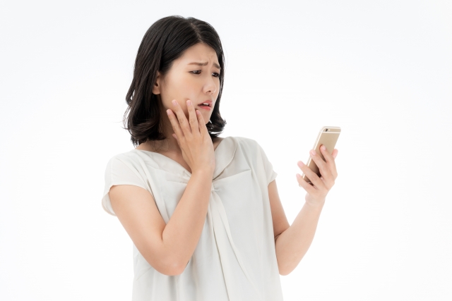 「婚活は難しい」とスマホを見ながら悩んでいる女性の写真。大阪結婚相談所ビリーブインユアセルフではこういう方の悩みを解消します。